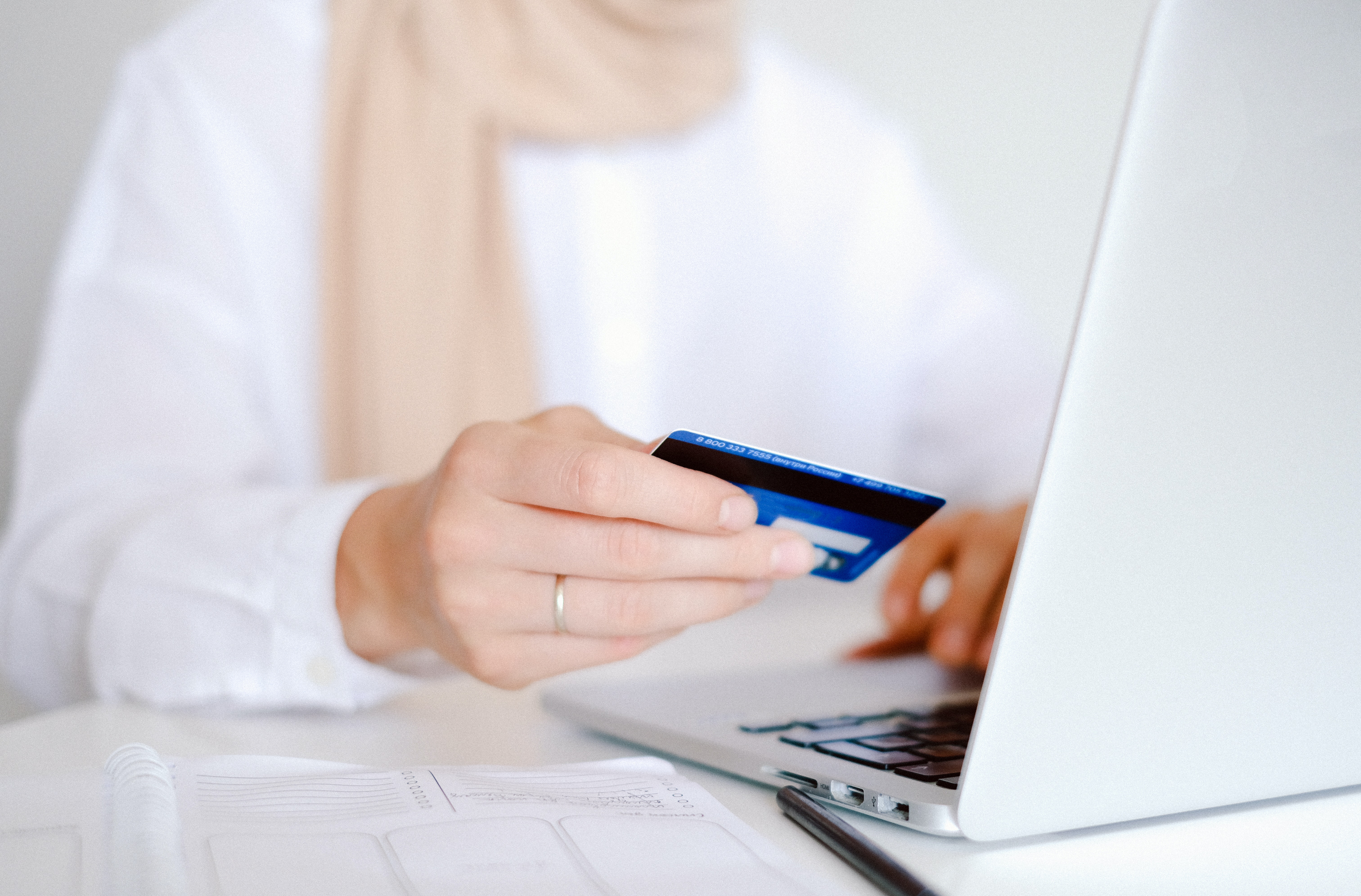 A woman in white dress makes an online payment through debit card